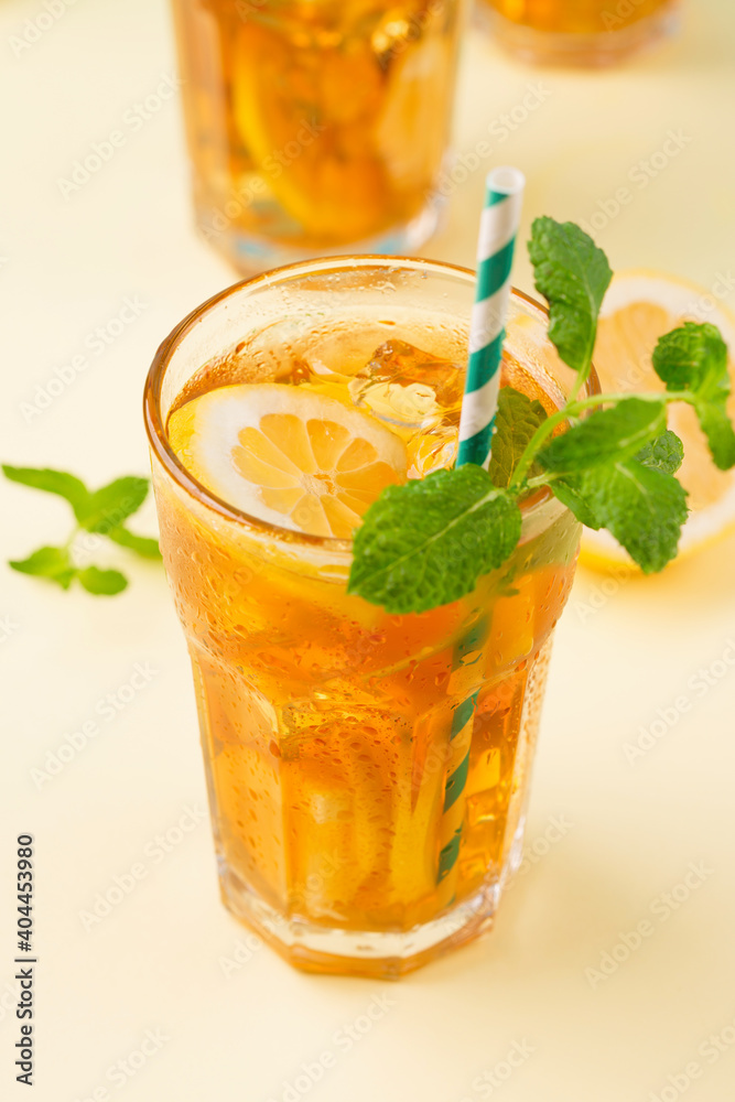 Fototapeta premium Traditional homemade iced tea with lemon, mint and ice in tall glasses. Summer cold drink concept.