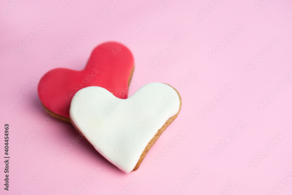 Two heart shaped cookies on  pink   background with   copy space. Valentines day greeting card .