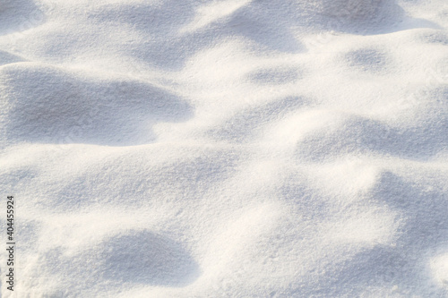 Small bumps of snow. Snow texture on a clear, sunny day. Natural background. Copy space, place for text.