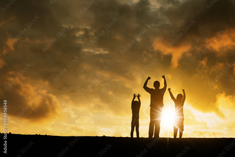 Fototapeta premium Two children chering with their father on hill peak