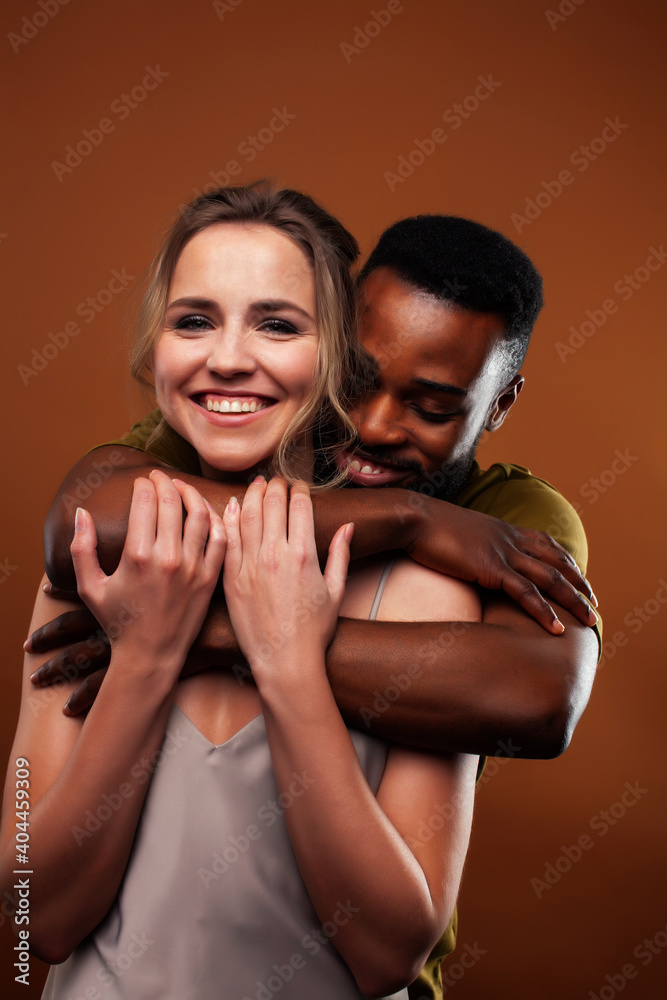 Obraz premium oung pretty couple diverse races together posing sensitive on brown background, lifestyle people concept
