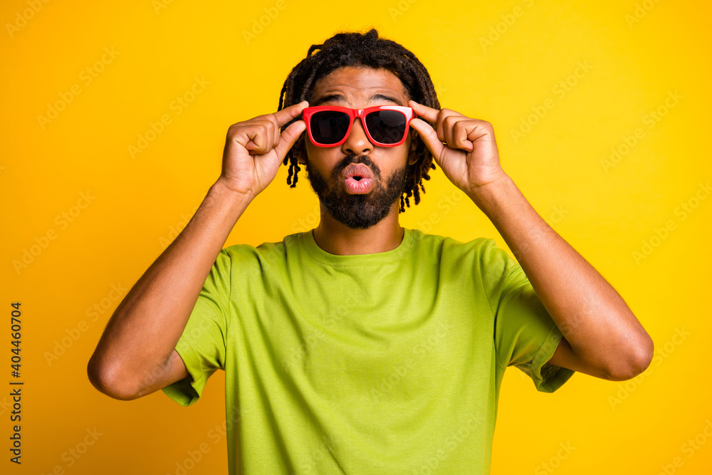 Photo of young man amazed shocked fake novelty news rumor hand touch sunglass isolated over yellow color background Photo of young man amazed shocked fake novelty news rumor hand touch sunglass isolated over yellow color background