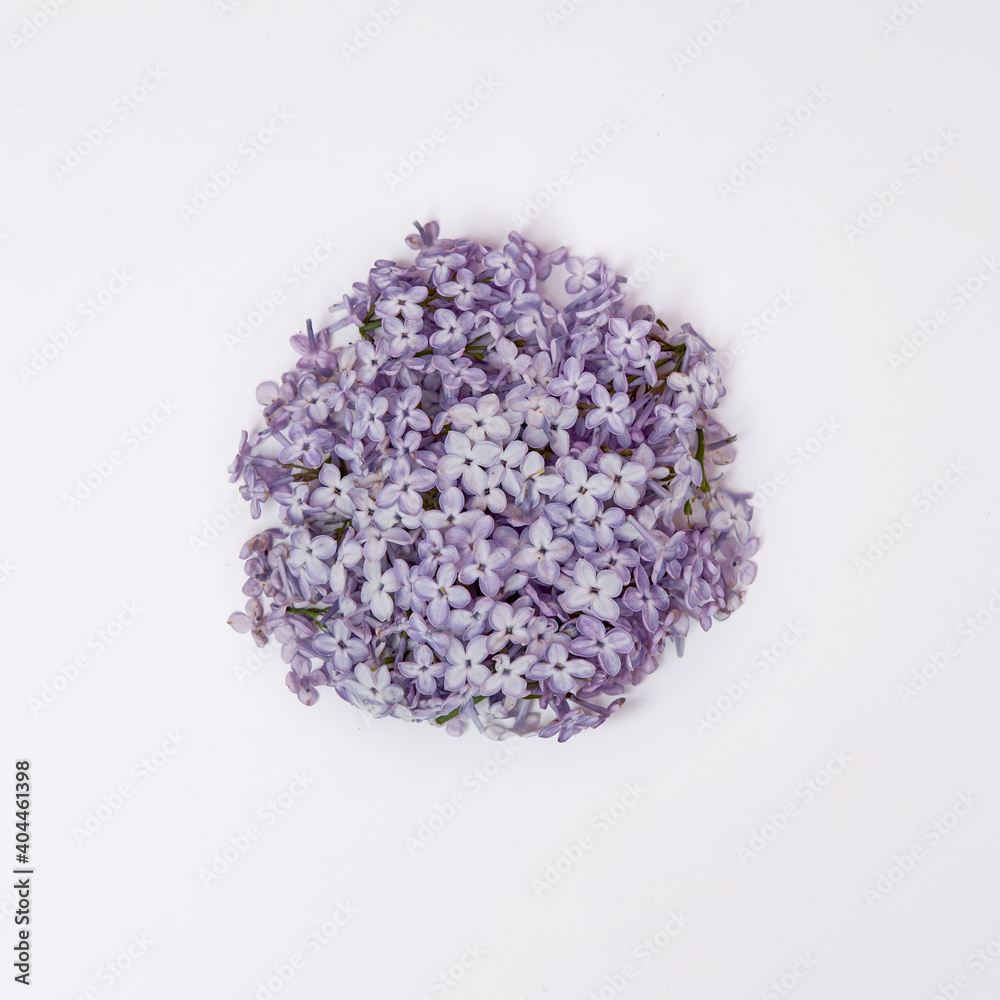 Flowers and lilac petals lie on a white table. Natural cosmetics Flowers and lilac petals lie on a white table. Natural cosmetics