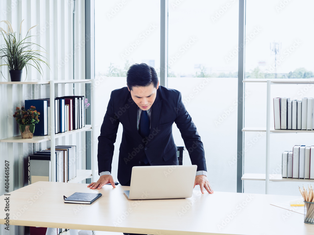 Asian handsome businessman in suit working with laptop computer on desk in office. Asian handsome businessman in suit working with laptop computer on desk in office.