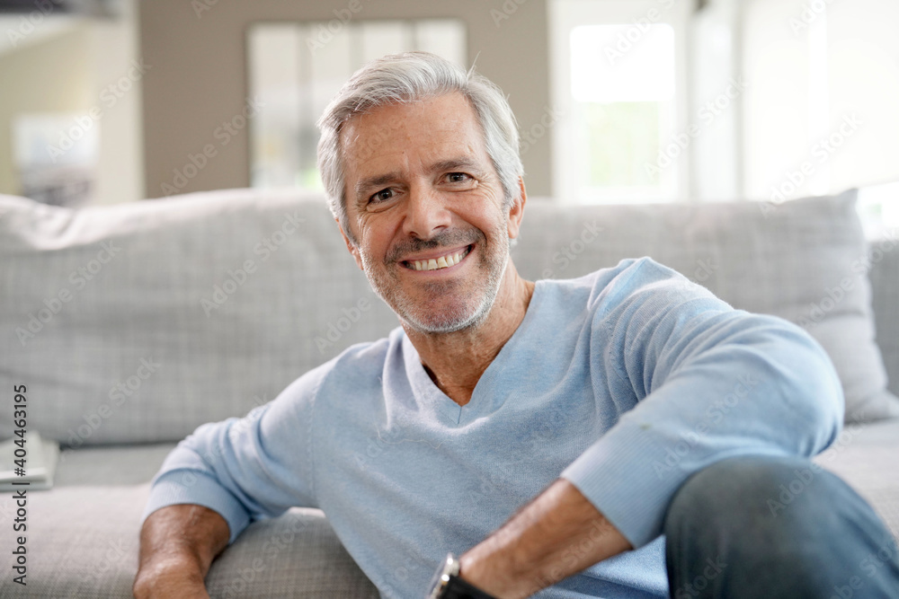 Portrait of attractive senior man with blue sweater relaxing at home - obrazy, fototapety, plakaty 