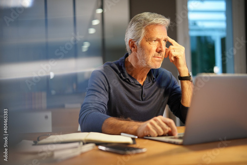 Portrait of senior man with grey hair connected with laptop