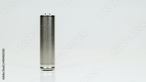AA alkaline rechargeable battery on white glossy background with reflection. Close one empty battery with copy space.