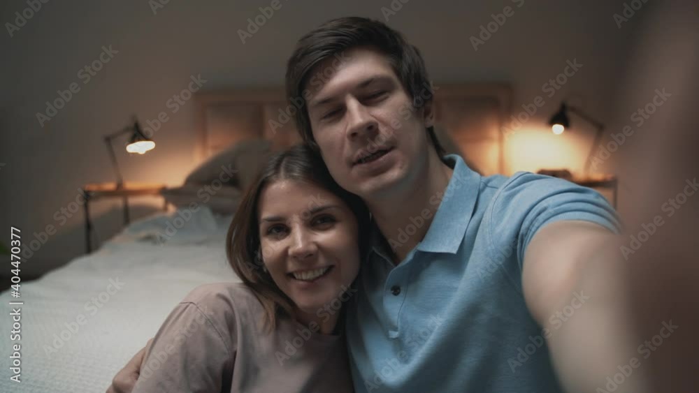 Young couple taking a selfie in bedroom, woman and man sharing moments Young couple taking a selfie in bedroom, woman and man sharing moments