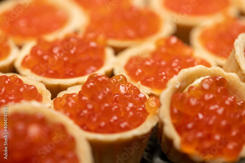 Tartlets with salmon caviar on a platter. Close-up, selective focus.