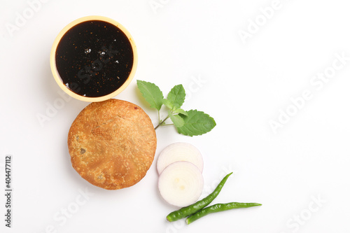 Kachori, green chilly and khatai on white background. Kachori is a spicy snack from India also spelled as kachauri and kachodi photo