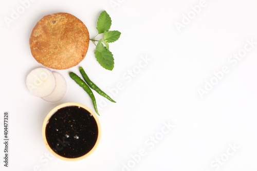 Kachori, green chilly and khatai on white background. Kachori is a spicy snack from India also spelled as kachauri and kachodi