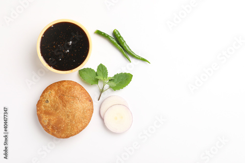 Kachori, green chilly and khatai on white background. Kachori is a spicy snack from India also spelled as kachauri and kachodi photo