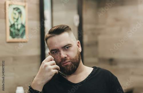 serious bearded man holds a straight razor