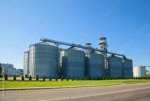 Granary. Modern agro-processing plant for the storage and processing of grain crops. Large metal barrels of grain. Horizontal image.