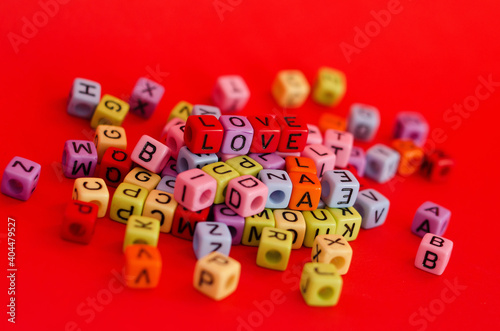Colorful wooden cube beads with letters on red festive background  word  love . Valentine Day. 14 of February. Flat lay  top view.
