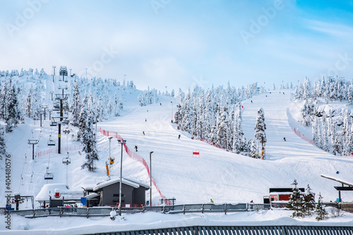 Skiers and snowboarders on the slopes of winter resort in Finland.