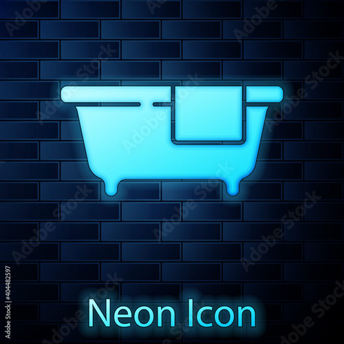 Glowing neon Bathtub icon isolated on brick wall background. Vector.