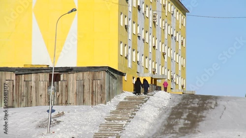 Communism block atmosphere. Russia. Tiksi. Siberia. Old people in on street of Tiksi. Abandoned housing block in northern Siberia. The architecture of the communist era.  photo