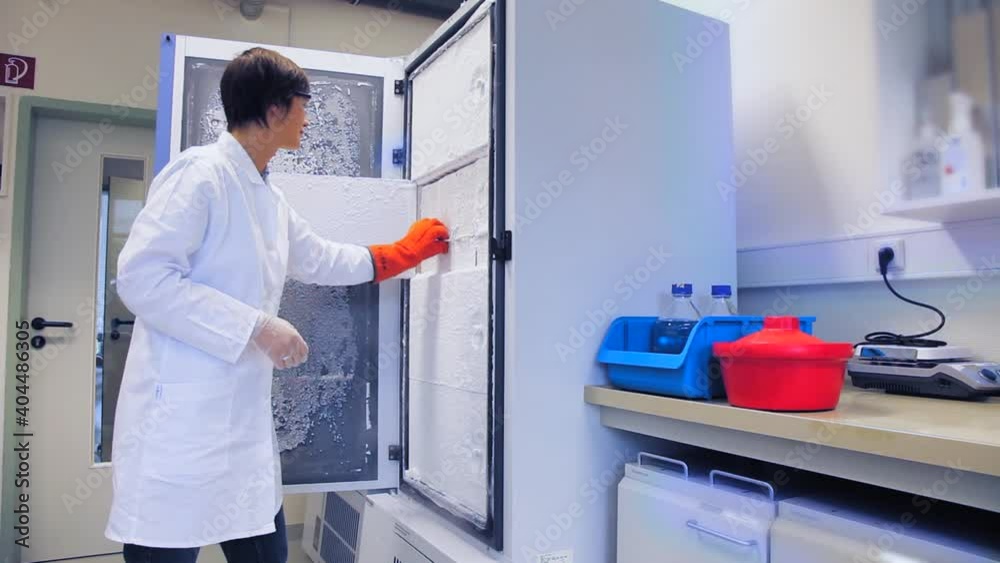 Woman take coronavirus vaccine from store vaccine in an ultra-cold freezer refrigerator. Woman take coronavirus vaccine from store vaccine in an ultra-cold freezer refrigerator.