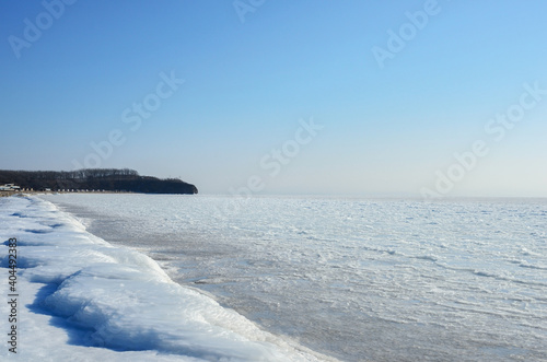 Frozen winter beach with frozen blocks of ice on the shore.