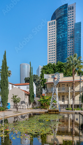 Water reflection of renovated German Templer colony  buildings over modern skyscrapers of Sarona district in Tel Aviv.