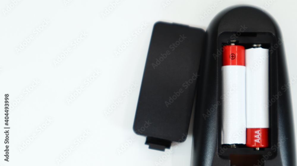Αυτοκόλλητο Black TV remote control with AAA alkaline batteries in red and white on a white background