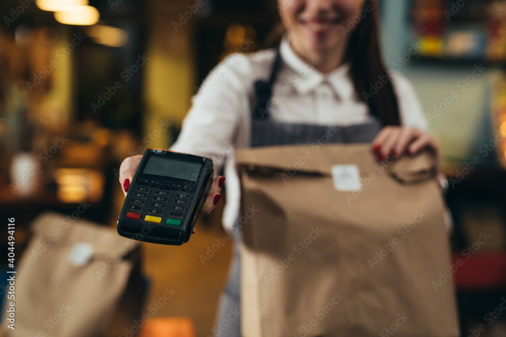 Φωτογραφία woman waitress holding take away food and card payment terminal in restaurant