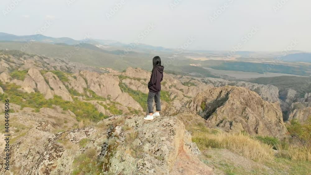 Aerial circle around attractive young caucasian woman enjoying dramatic Birtvisi landscape views Aerial circle around attractive young caucasian woman enjoying dramatic Birtvisi landscape views