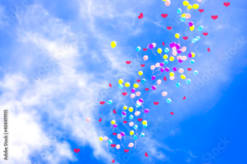Valentine's day, colorful balloons with hearts on a background of blue sky and white clouds