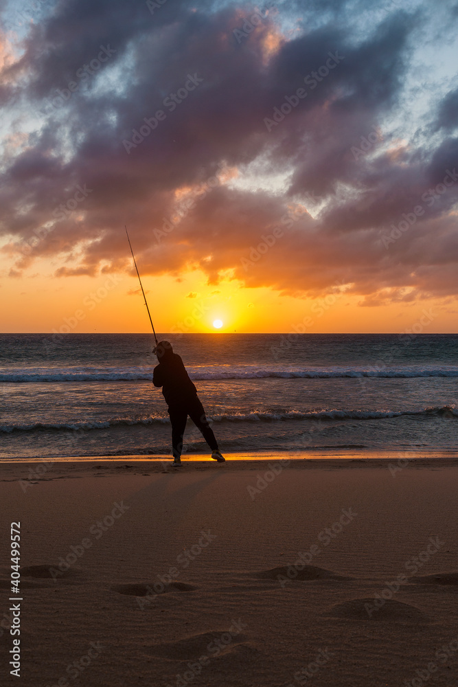Un hombre pescando en la playa de Los Lances al atardecer, en Tarifa, Provincia de Cádiz, Andalucía, España