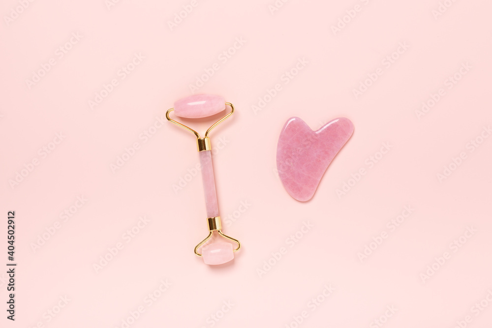 Gua Sha massager and face roller on powdery background. Massage tool for facial skin care, SPA beauty treatment concept Gua Sha massager and face roller on powdery background. Massage tool for facial skin care, SPA beauty treatment concept