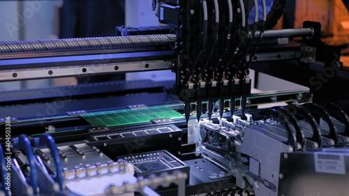 Assembly of computer circuit board - automatic SMD pick and place machine during work at factory, exhibition. Automated technology, industrial, robotic, electronic, production, manufacturing concept