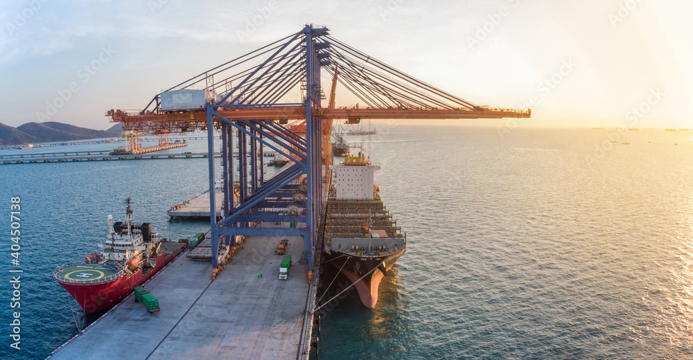 Crane loading cargo container to cargo ship stand by in the international terminal smart logistic sea port  concept smart freight shipping by ship at sunset.