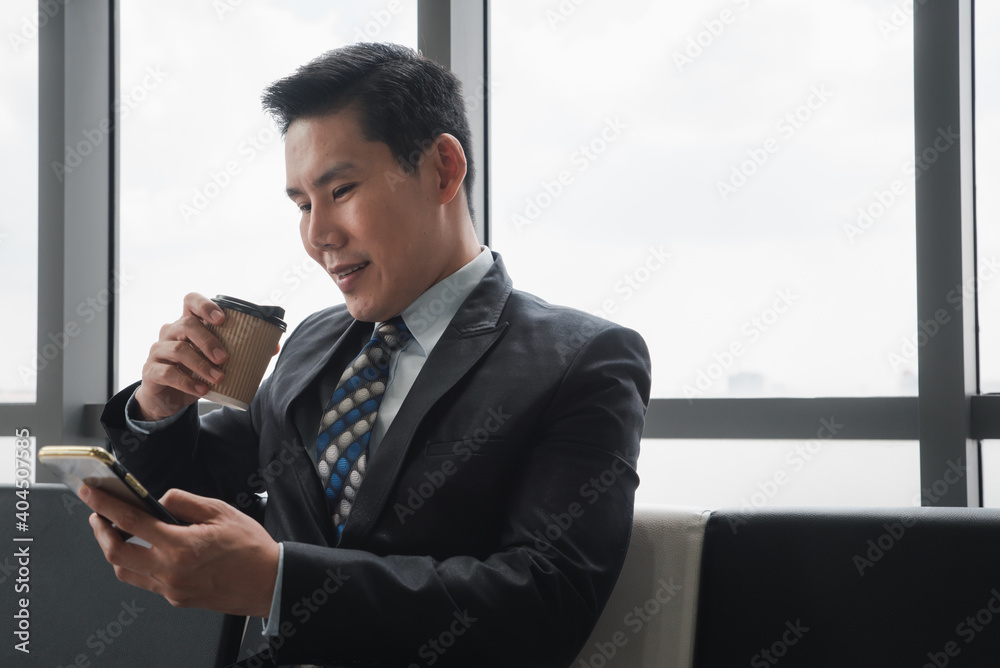 Businessman holding coffee cup and looking at smartphone. Businessman holding coffee cup and looking at smartphone.