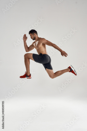 Young caucasian professional sportsman jumping high