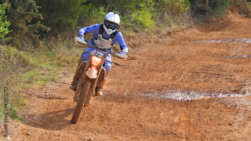Zoom photo of professional motocross rider on his motorcycle on extreme dirt and mud terrain track. Biker flying on a motocross motorcycle.