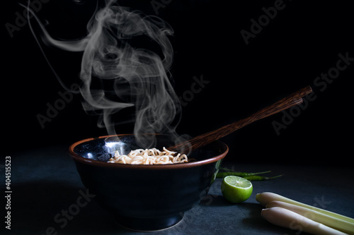 Hot soup noodles in a bowl on a black marble table with Asian instant noodle.