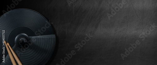 Obraz na plátně Black cymbal of an electronic drum kit and a pair of wooden drumsticks on a blank blackboard with copy space