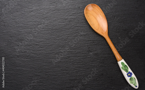 empty vintage wooden spoon with ceramic handle on black background