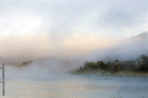 A foggy day at Lake Turano. The colors of autumn in Castel di Tora in Rieti