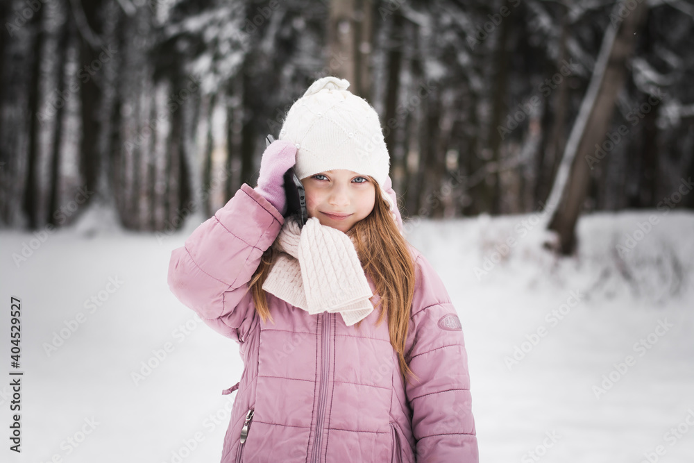 Beautiful little girl five years old portrait in a snowy city park