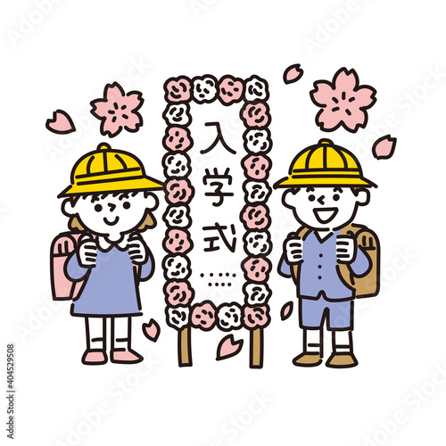 小学校入学式の看板の前に立つ小学生の男女