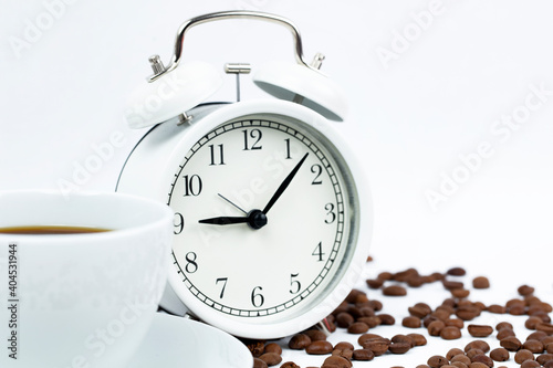 Morning cup of coffee and alarm clock.White background. 