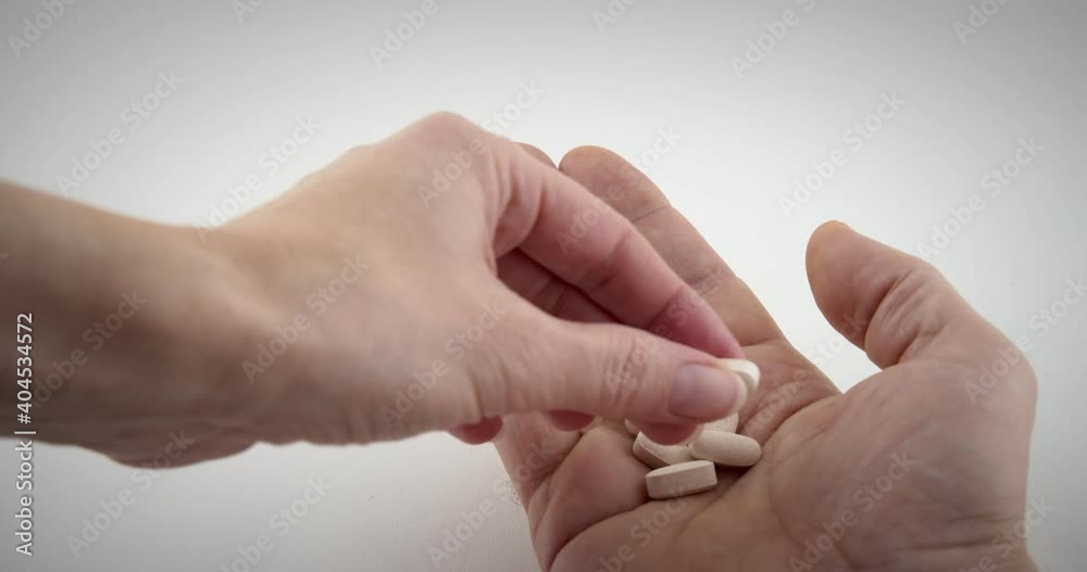 Close up of doctor or pharmacist hand giving brown medicine drugs, pills to the patient in white isolated background. 4k slow motion Close up of doctor or pharmacist hand giving brown medicine drugs, pills to the patient in white isolated background. 4k slow motion