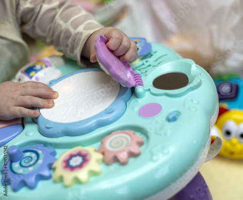 Baby hand playing with toy. Little baby hand pianist plays on a colorful toy piano.