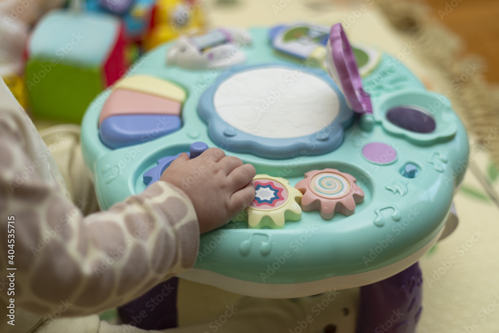 Baby hand playing with toy. Little baby hand pianist plays on a colorful toy piano.