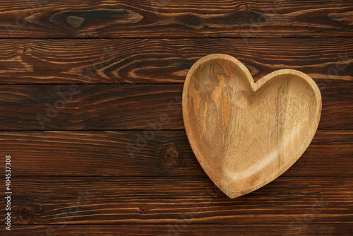 Heart plate on brown wooden background. Top view. Copy space. Valentines day celebration concept