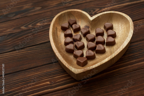 Chocolates hearts on brown wooden background. Top view. Copy space. Valentines day celebration concept