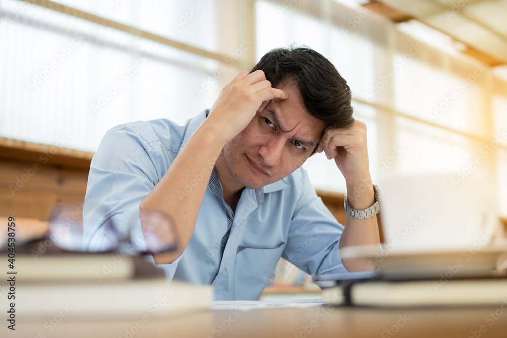Stressed businessman is working at office. Tired businessman looking at camera. Stressed businessman is working at office. Tired businessman looking at camera.