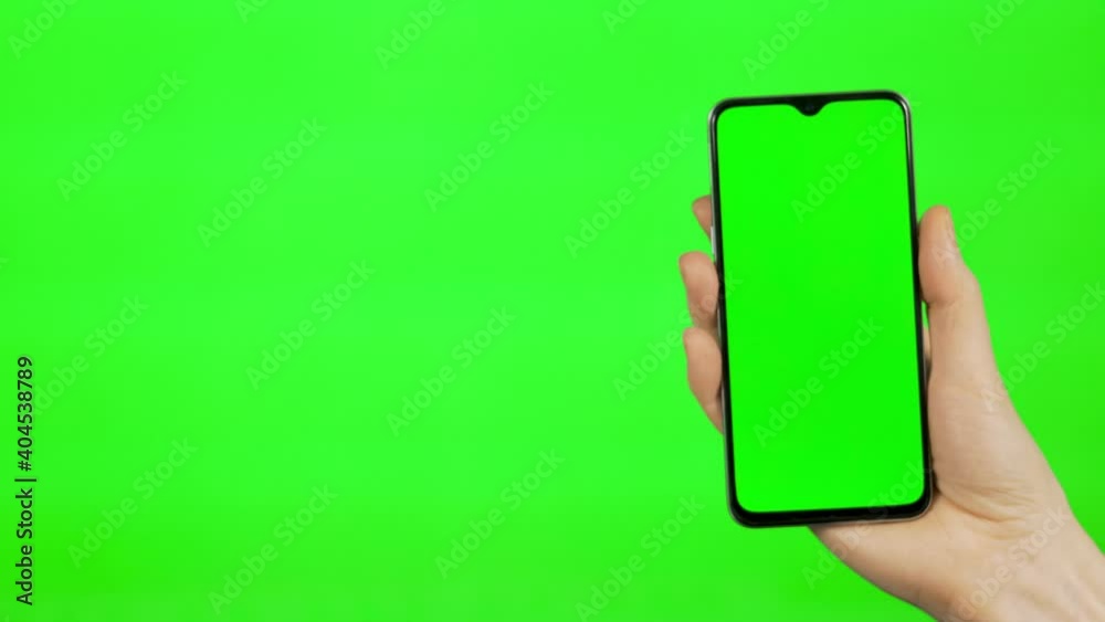 Hand of a Businessman Holding a Smartphone with Green Screen Vertical on Green Background, Alpha Channel, Chroma key, Mock up. Blogging, Watching Video Content, Internet. Hand of a Businessman Holding a Smartphone with Green Screen Vertical on Green Background, Alpha Channel, Chroma key, Mock up. Blogging, Watching Video Content, Internet.